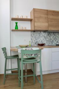 a kitchen with a table and a green chair at Seaside Apartments - Central Apartments with View - Molfetta in Molfetta