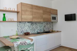 a kitchen with white cabinets and a table and a microwave at Seaside Apartments - Central Apartments with View - Molfetta in Molfetta