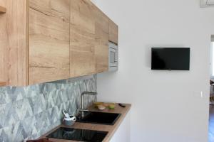 a kitchen with a sink under a wooden cabinet at Seaside Apartments - Central Apartments with View - Molfetta in Molfetta