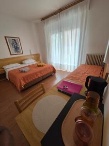 a hotel room with two beds and a table with a table at The green house in Malcesine