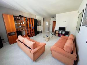a living room with two orange couches in a room at Dimora Il Roseto in Trani
