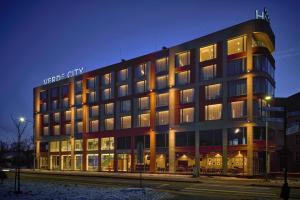 a large building with a sign on top of it at Hotel Verde City in Koszalin