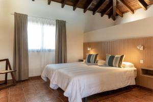 a bedroom with a large white bed and a window at Sweet Caroline in Villaverde