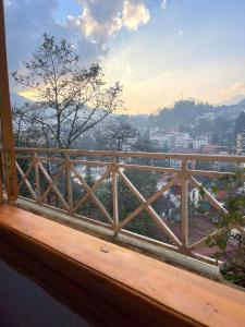 a wooden balcony with a view of a city at SUN Homestay sa pa in Sapa