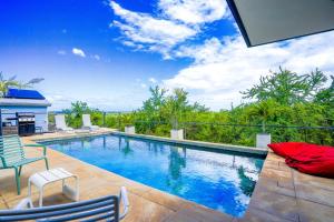 a large swimming pool with two chairs at LA MAISON DES JADES in La Saline les Bains