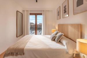 a bedroom with a large white bed with a window at Casa "Valldemossa Paradise" in Valldemossa +38 photos