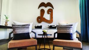 a room with two chairs and a large letter e on the wall at Golden Temple Villa in Siem Reap
