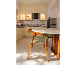 a kitchen with a table and chairs and a refrigerator at Casa De Alegria Goa in Canacona