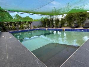 a swimming pool with a green canopy over it at Luzviminda Farm Homestay in Coron