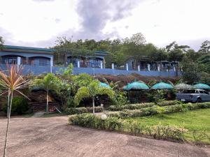 a house with umbrellas in front of it at Luzviminda Farm Homestay in Coron