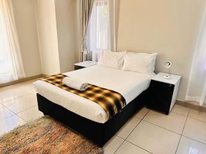 a bedroom with a bed with a checkered blanket on it at Thetsane Ridge in Maseru