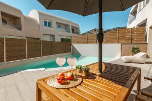 a table with an umbrella and fruit on a patio at Tortuga Luxury Villas Sivota in Syvota