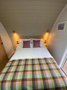 a bed with two pillows in a small room at Dornoch Pods in Dornoch
