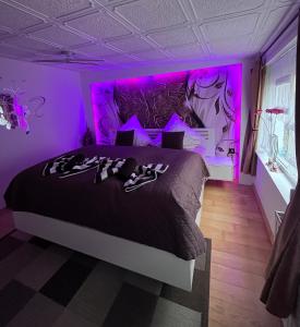 a purple bedroom with a bed with shoes on it at Ferienwohnung Heyne in Weinböhla