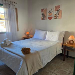 a bedroom with a large bed with white sheets at Refúgio da Guta in Tiradentes
