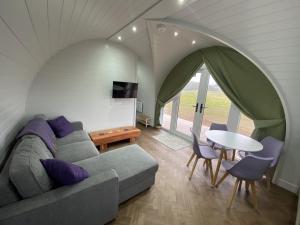 a living room with a couch and a table at Dornoch Pods in Dornoch