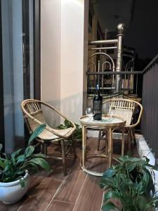 a balcony with two chairs and a table with a bottle of wine at Mom's home in Ninh Binh