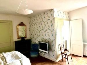 a bedroom with a bed and a tv on a wall at Les Glycines 23300 in La Souterraine