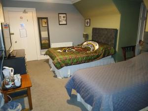 a hotel room with two beds and a table at Greenland House B&B in Castletown