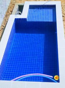 a swimming pool with blue tiles on the roof at Lajedalu in Aquiraz
