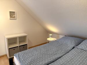 a bedroom with a bed with a blue comforter at Seewiefken 2 Dümmerblick in Lembruch