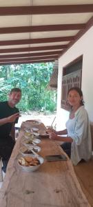 a man and woman sitting at a table with food at Hideout Deniyaya in Deniyaya