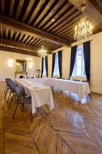 a large room with white tables and chairs and chandeliers at Maison Philippe Le Bon Hôtel, Restaurant & Bar le 19 in Dijon