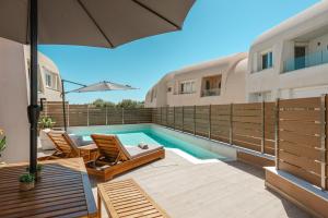 a backyard with a swimming pool and two chairs and an umbrella at Tortuga Luxury Villas Sivota in Syvota