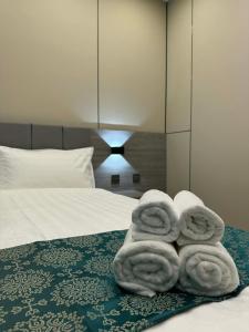 Ein Stapel Handtücher lag auf einem Bett. in der Unterkunft Ashid in Ulaanbaatar