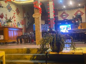 a stage with a potted plant and a tv in a room at SUN Homestay sa pa in Sapa