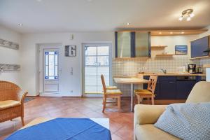 a kitchen and living room with a table and chairs at Haus Meyer-Teerling - Ferienhaus in Borkum +16 photos
