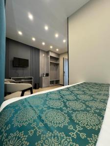ein Hotelzimmer mit einem großen Bett und einem Fernseher in der Unterkunft Ashid in Ulaanbaatar