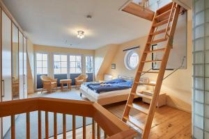 a bedroom with a bunk bed and a ladder at Haus Meyer-Teerling - Ferienhaus in Borkum