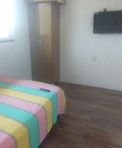 a room with a bed with a colorful blanket at Lajedalu in Aquiraz +9 photos