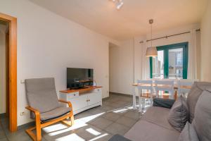 a living room with a couch and a television and a table at Apartaments Rural Montseny in gualba de Dalt