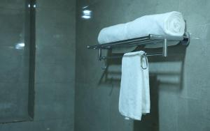a towel rack with towels in a bathroom at VijayLord's palace Badrinath in Badrinath