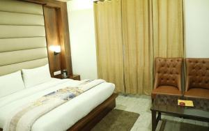 a hotel room with a bed and a chair at VijayLord's palace Badrinath in Badrinath