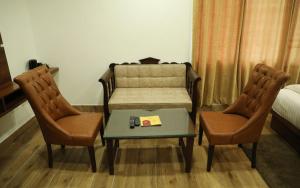a room with two chairs and a table and a bed at VijayLord's palace Badrinath in Badrinath