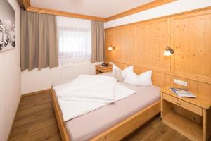 a bedroom with a bed with a wooden wall at Appartement Moaeben in Alpbach