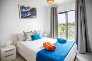 a bedroom with a bed with orange and blue pillows at Stylish Central Three Bed Duplex with Private Pool in Flic-en-Flac +52 photos
