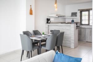 a dining room with a table and chairs at Stylish Central Three Bed Duplex with Private Pool in Flic-en-Flac