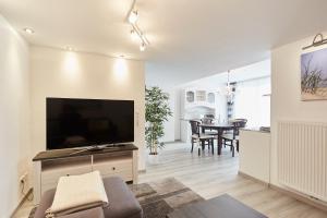 a living room with a large flat screen tv on a cabinet at Ferienhaus Lina in Borkum