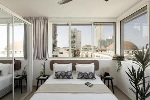 a bedroom with a bed with a view of a city at Mr Rothschild By TLV2GO in Tel Aviv