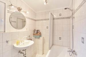 a white bathroom with a sink and a shower at Ferienhaus Lina in Borkum +16 photos