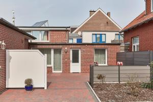 a white refrigerator in front of a brick house at Ferienhaus Lina in Borkum