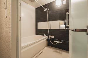 a bathroom with a bath tub and a shower at The LOFT INN NAGASAKI in Nagasaki