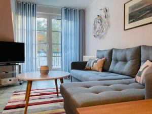 a living room with a couch and a table at Achtern Diek 12b - Wohnung 5 in Müggenburg
