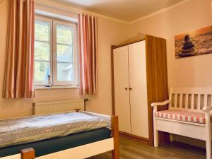 a bedroom with a bed and a cabinet and a window at Achtern Diek 12b - Wohnung 5 in Müggenburg