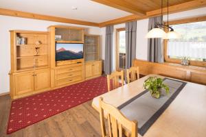 a dining room with a table and a television at Appartement Moaeben - Panorama in Alpbach