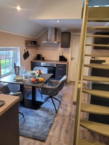 a kitchen and dining room with a table and a ladder at Wohnung Burghaus 5 OG in Krummhörn